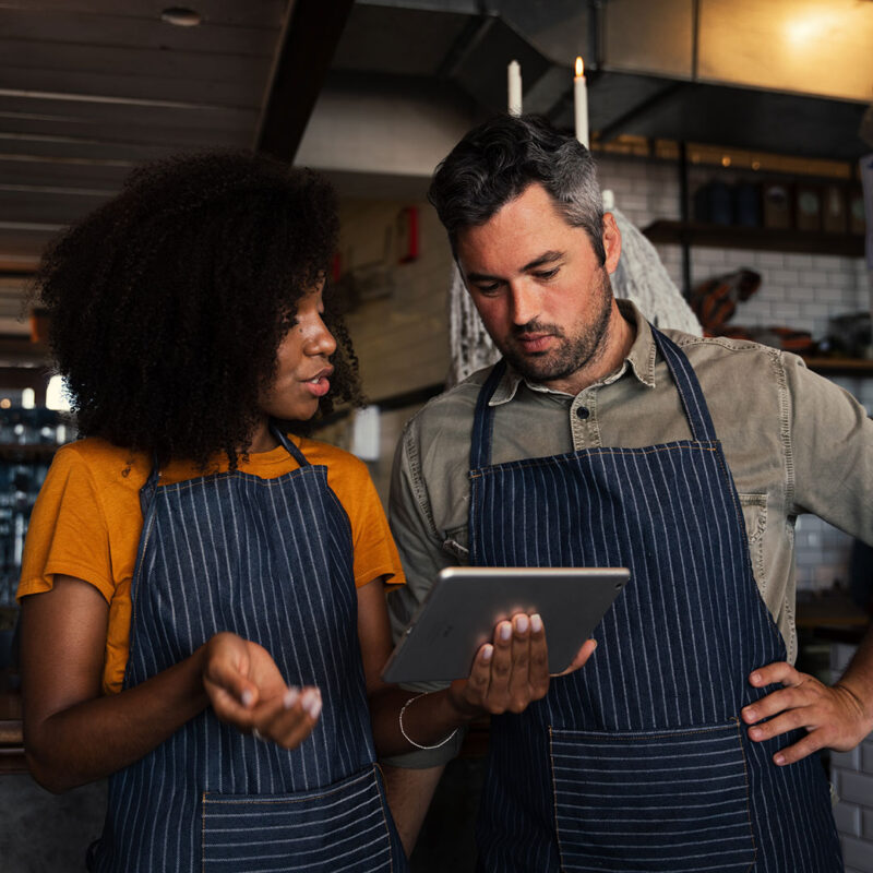 Foto de dueños de restaurantes hablando sobre qué hacer con los impuestos sobre las ventas atrasados. ¿Qué debo hacer si mi negocio está atrasado en el impuesto sobre las ventas?