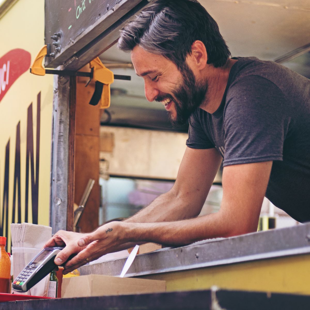 man in food truck accepts card payment via POS system