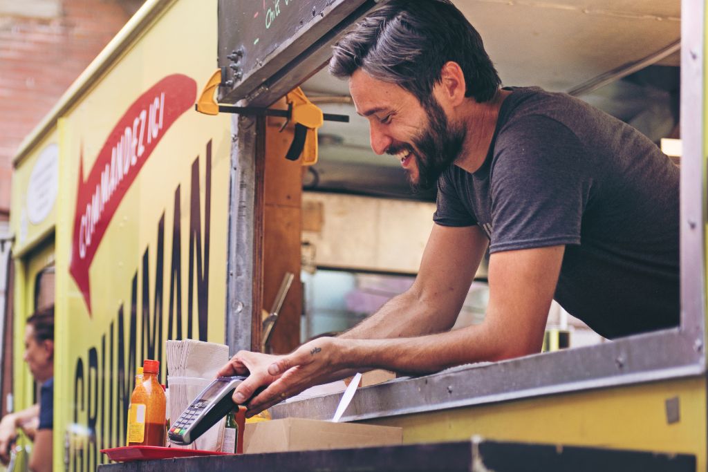 Man in food truck accepts payments via POS system