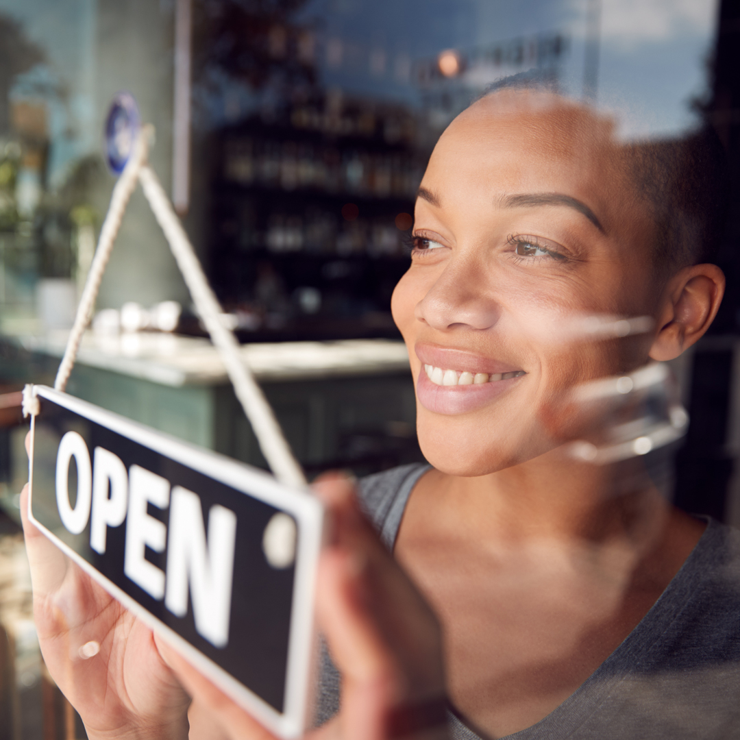 woman holding an open sign