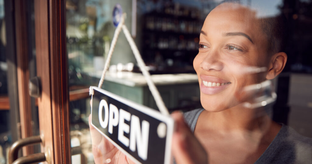 Mujer sosteniendo un cartel abierto 