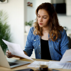 Mujer revisando sus impuestos frente a una computadora