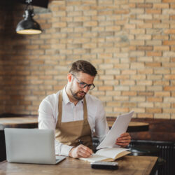 restaurant worker doing finances with computer