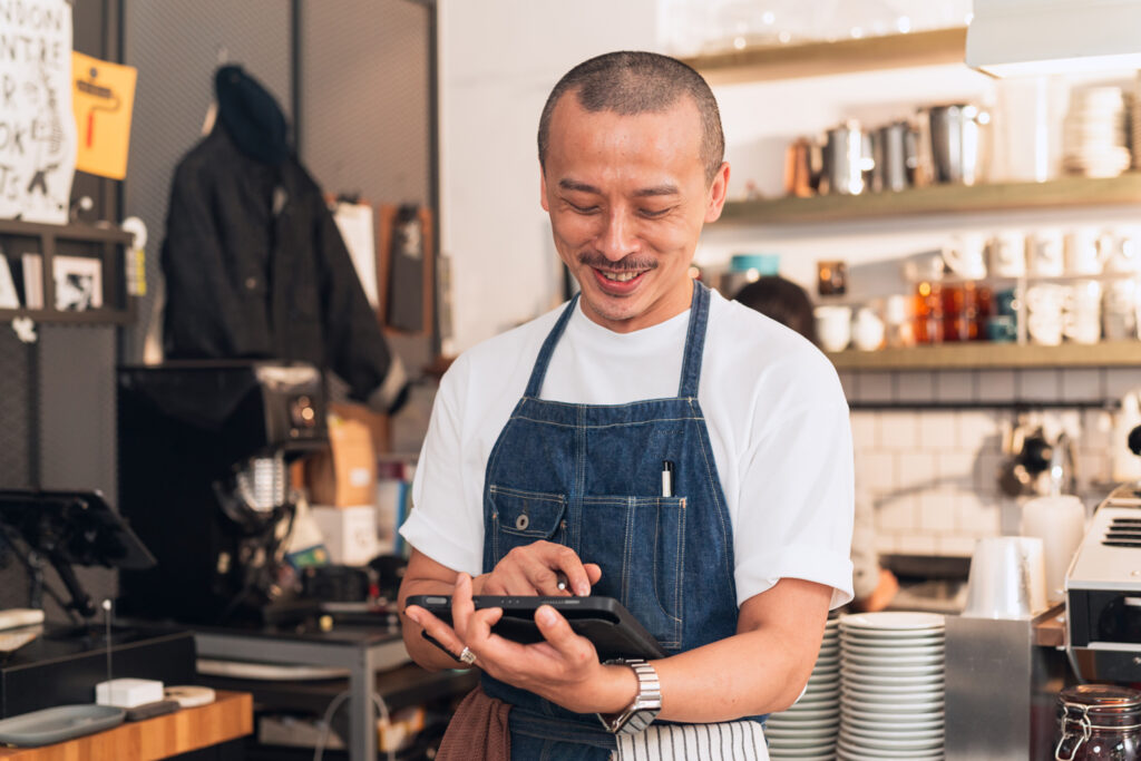 El dueño del restaurante mira felizmente el TPV