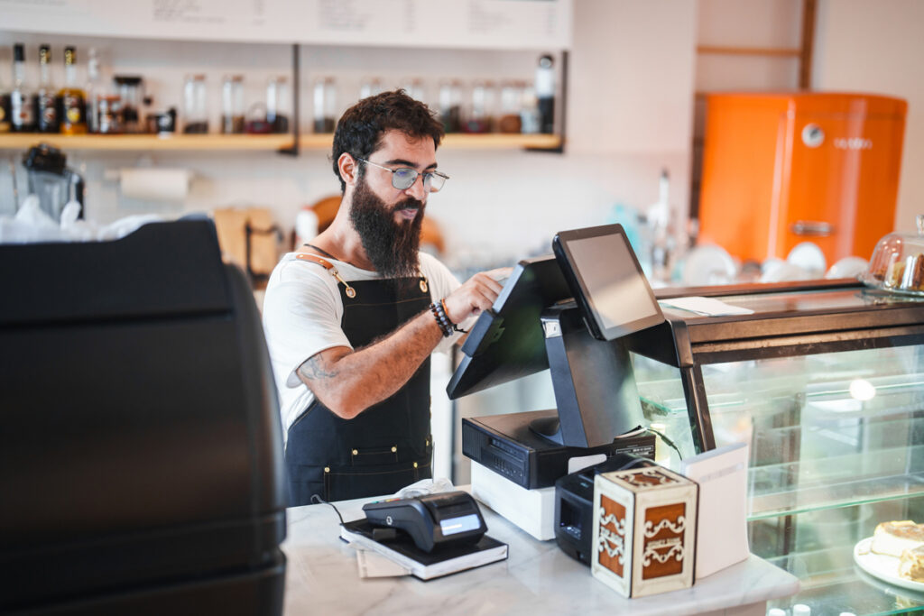 Worker at cafe navigating through POS
